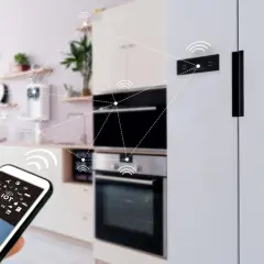 Moderne Küche mit vernetzten Geräten, die über ein Smartphone gesteuert werden. Die smart home funkstandards ermöglichen nahtlose Kommunikation.