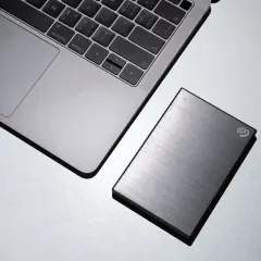 Silbernes Laptop neben einer externen Seagate Hybrid HDD.