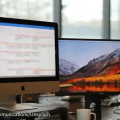 Zwei Monitore getrennt nutzen: Links ein Kalender, rechts eine Berglandschaft mit See. Effizientes Arbeiten und entspannender Ausblick.