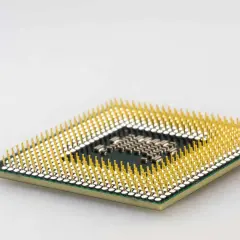 Ein Prozessor mit vielen goldenen Pins. Er ist das Gehirn des Computers und entscheidet, was der Prozessor macht.