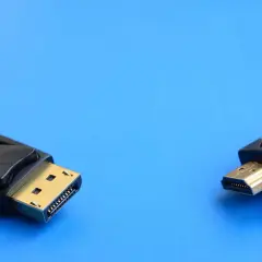 Ein DisplayPort-Stecker und ein HDMI-Stecker liegen nebeneinander. Verschiedene DisplayPort-Versionen bieten unterschiedliche Übertragungsraten.