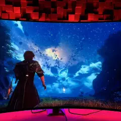 Breiter 21:9-Monitor zeigt eine Fantasy-Landschaft mit schwebenden Felsen und Sternenhimmel. Eine Figur blickt in die Ferne.