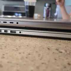 Zwei MacBooks liegen übereinander. Das untere Modell hat mehr Anschlüsse. Das geringe MacBook Air Gewicht macht es zum idealen Reisebegleiter.