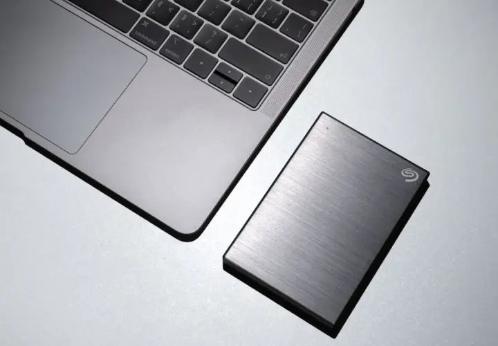 Silbernes Laptop neben einer externen Seagate Hybrid HDD.