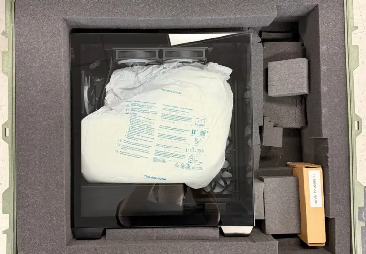 PC sicher verpackt für den Transport in einem gepolsterten Koffer. Die Schutzhülle zeigt "This side DOWN".