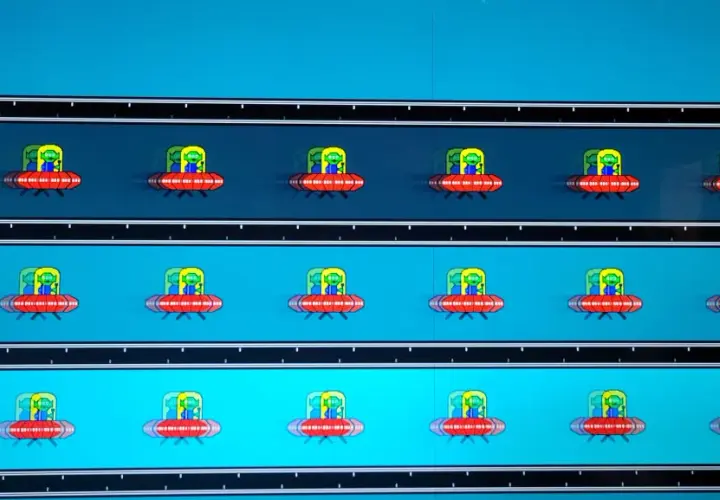 Mehrere rote UFOs mit grünen Aliens fliegen auf einem blauen Hintergrund. Deutliches **Monitor Ghosting** erzeugt Schlieren.