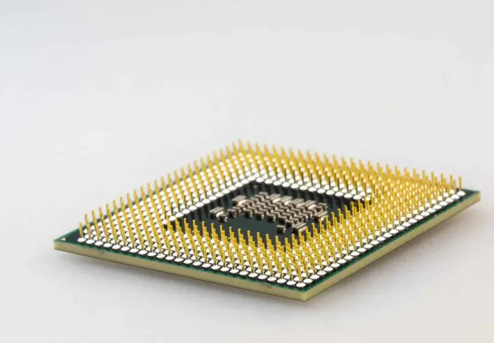 Ein Prozessor mit vielen goldenen Pins. Er ist das Gehirn des Computers und entscheidet, was der Prozessor macht.