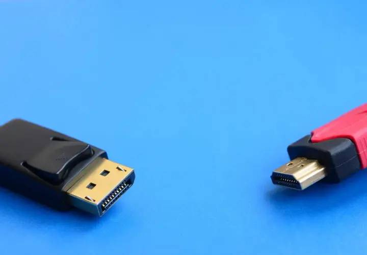 Ein DisplayPort-Stecker und ein HDMI-Stecker liegen nebeneinander. Verschiedene DisplayPort-Versionen bieten unterschiedliche Übertragungsraten.