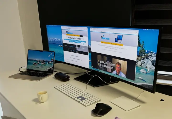 Ein Arbeitsplatz mit mehreren Bildschirmen eingerichtet. Ein Laptop, eine Tastatur, Mäuse und eine Kaffeetasse stehen auf dem Schreibtisch.