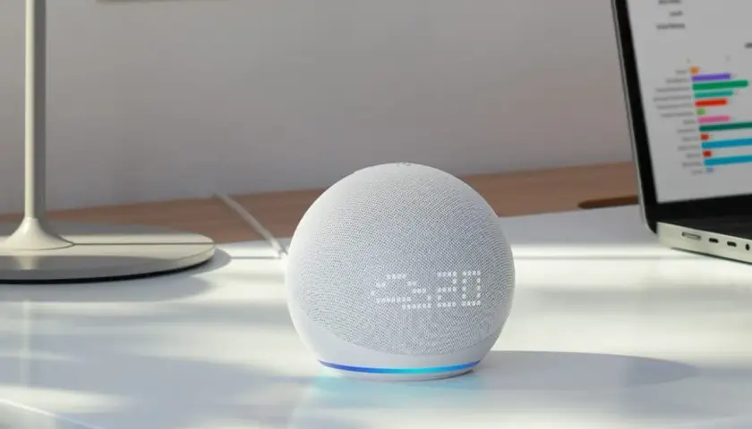 Echo Dot mit integriertem Temperatursensor zeigt 23:20 an. Ein Laptop mit Diagrammen steht daneben.