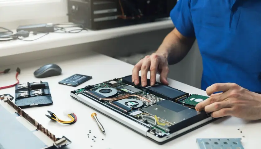 Mann baut Festplatte in Laptop ein. Ein Upgrade für mehr Speicherplatz.