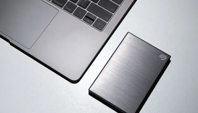 Silbernes Laptop neben einer externen Seagate Hybrid HDD.