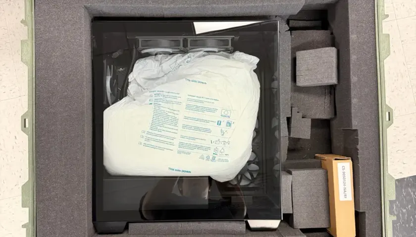 PC sicher verpackt für den Transport in einem gepolsterten Koffer. Die Schutzhülle zeigt "This side DOWN".