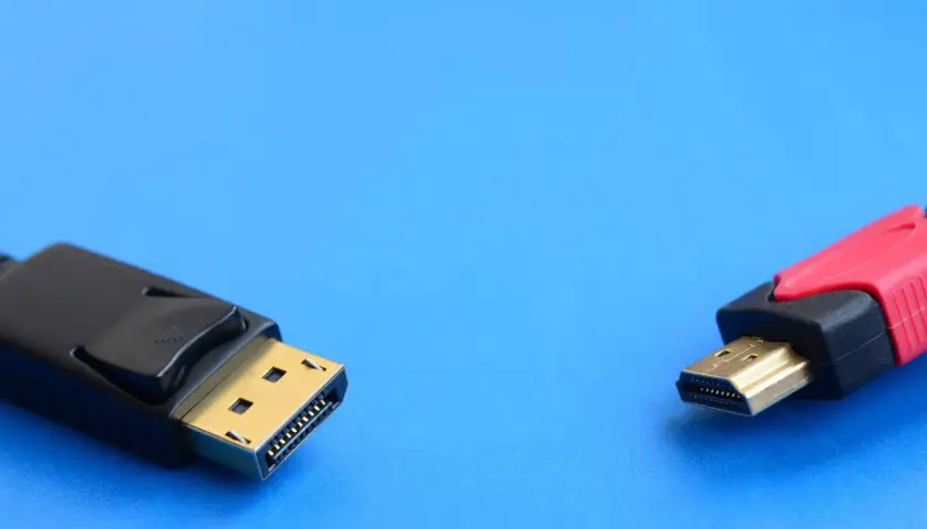 Ein DisplayPort-Stecker und ein HDMI-Stecker liegen nebeneinander. Verschiedene DisplayPort-Versionen bieten unterschiedliche Übertragungsraten.