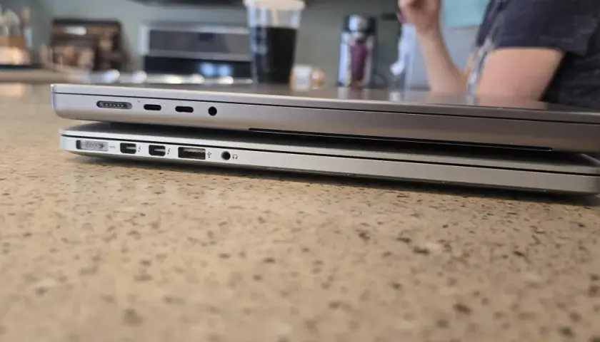 Zwei MacBooks liegen übereinander. Das untere Modell hat mehr Anschlüsse. Das geringe MacBook Air Gewicht macht es zum idealen Reisebegleiter.