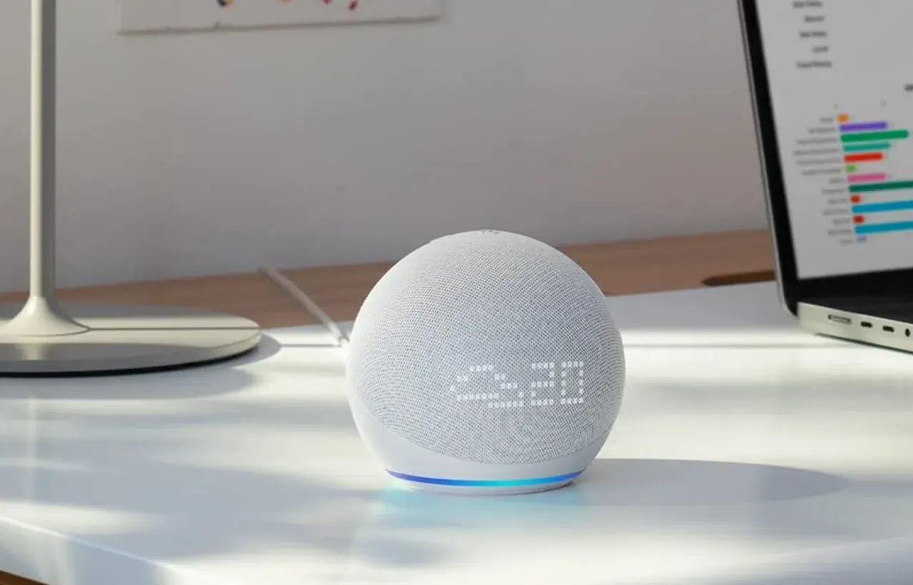 Echo Dot mit integriertem Temperatursensor zeigt 23:20 an. Ein Laptop mit Diagrammen steht daneben.