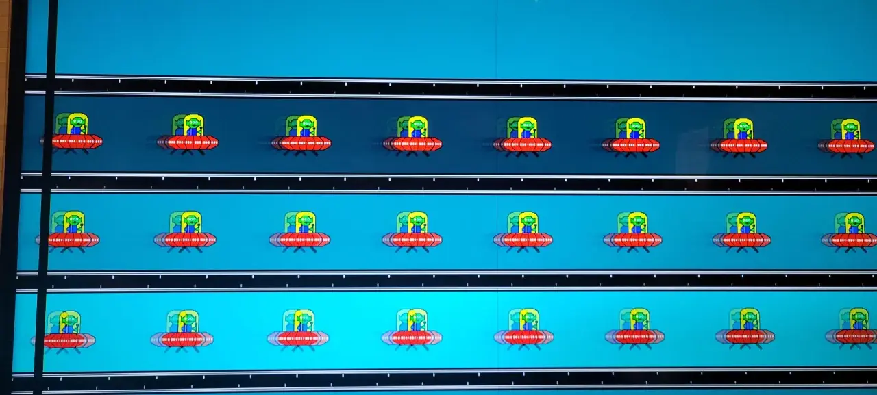 Mehrere rote UFOs mit grünen Aliens fliegen auf einem blauen Hintergrund. Deutliches **Monitor Ghosting** erzeugt Schlieren.