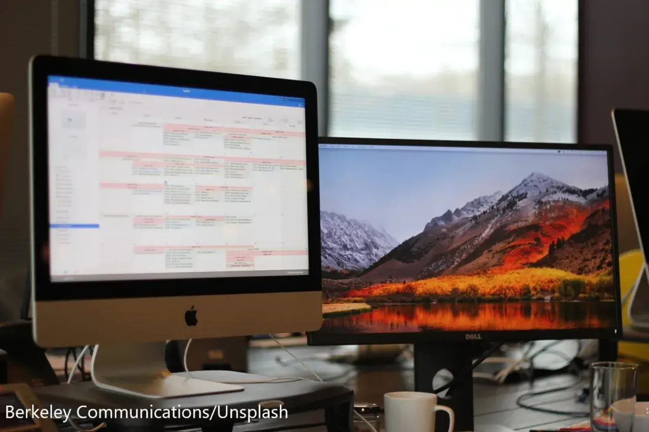 Zwei Monitore getrennt nutzen: Links ein Kalender, rechts eine Berglandschaft mit See. Effizientes Arbeiten und entspannender Ausblick.