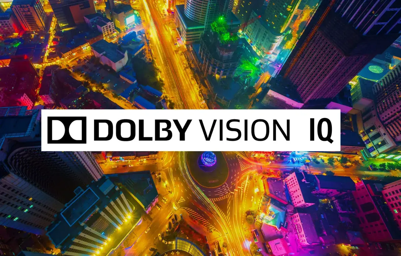 Bunte Stadt bei Nacht, beleuchtet von Straßenlaternen und Gebäuden. Das Logo "Dolby Vision IQ" überlagert die Szene und verspricht ein immersives Seherlebnis.