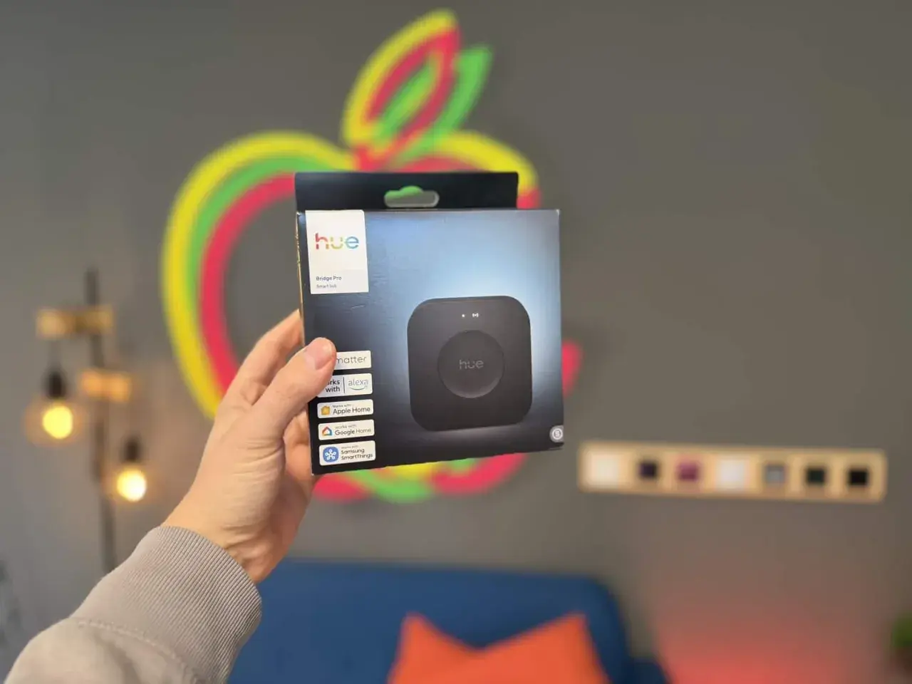 Hand hält Hue Bridge Pro Smart Hub Verpackung. Ideal, um zwei Hue Bridges zu koppeln und dein Smart Home zu erweitern.