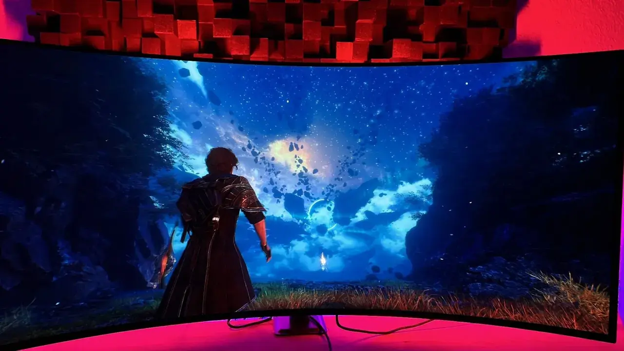 Breiter 21:9-Monitor zeigt eine Fantasy-Landschaft mit schwebenden Felsen und Sternenhimmel. Eine Figur blickt in die Ferne.