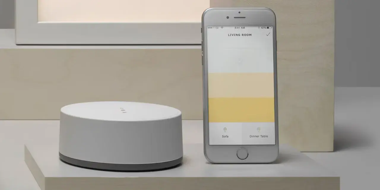 Ein Smartphone zeigt eine App zur Steuerung von adaptiven Licht. Daneben ein weißer Hub.