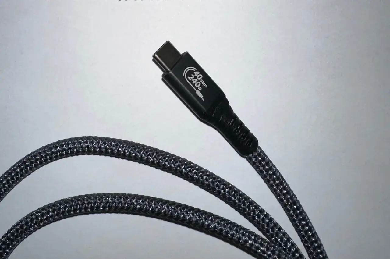 Ein schwarzes Kabel mit geflochtenem Mantel und einem USB-C-Stecker, der mit "40Gbps 240W" beschriftet ist. Dieser USB 4 Anschluss ist bereit für schnelle Datenübertragung und hohe Leistung.