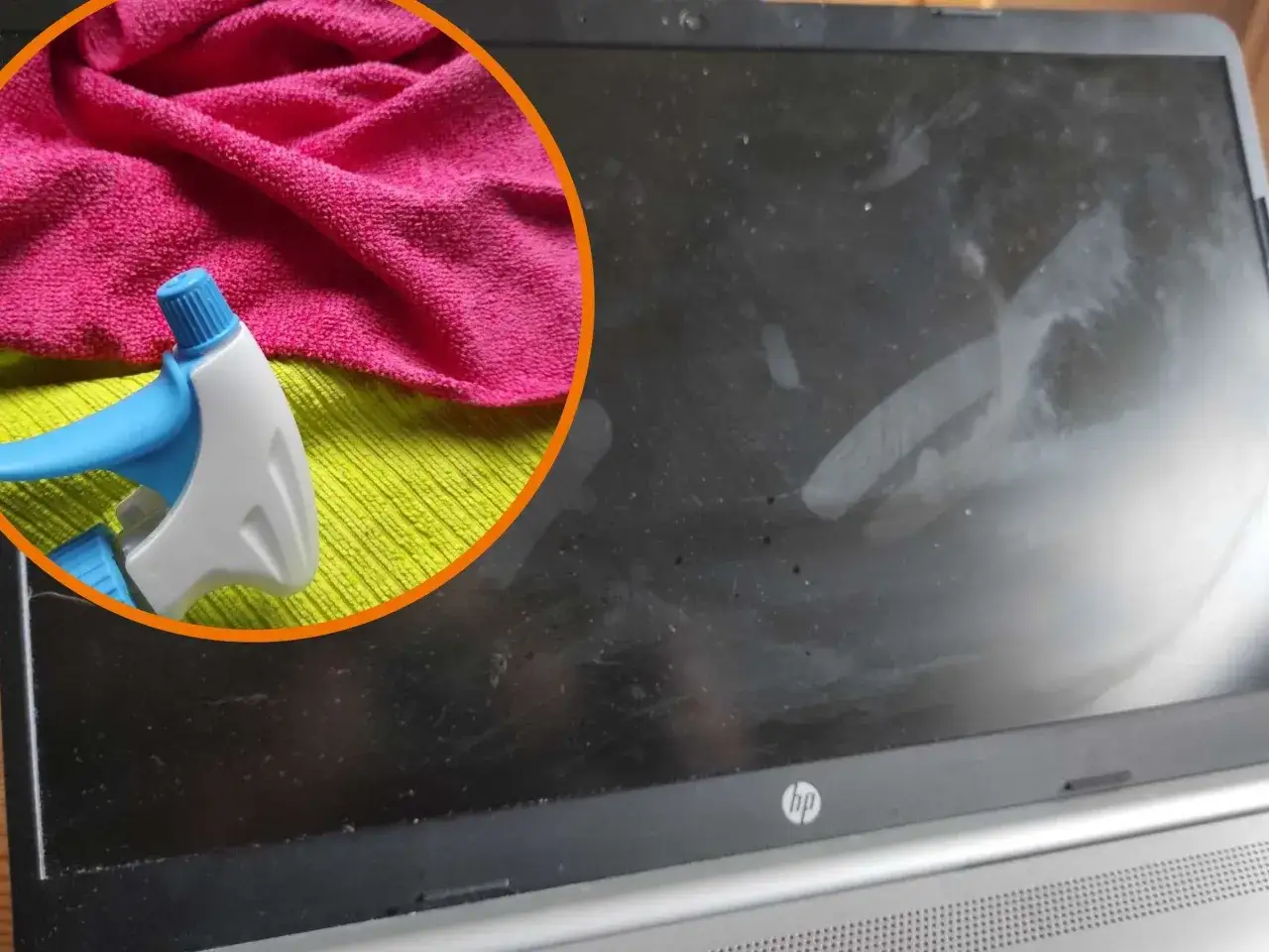 Ein pinkes Mikrofasertuch und eine Spr&uuml;hflasche sind bereit, um den staubigen Laptop-Bildschirm zu reinigen.