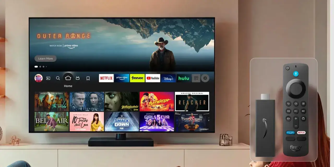 Ein Smart-TV mit dem vega OS-Interface, das Apps wie Netflix und Prime Video zeigt. Daneben ein Fire TV Stick und Fernbedienung.